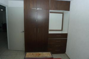 a large wooden cabinet in a room with a mirror at Room in a shared apartment full of peace in Tonalá