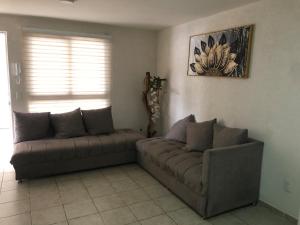 a living room with two couches in a room at Room in a shared apartment full of peace in Tonalá