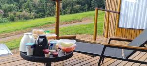 a table with food and drinks on a deck at Domo da Montanha in Monte Verde
