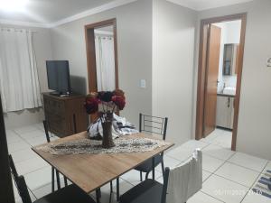 een eettafel met een vaas met bloemen erop bij Apartamento Ótima Localização Turismo Faculdade in Bento Gonçalves +23 foto's