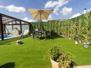 a garden with a table and an umbrella at Only adults rural house in Burgos in Barbadillo del Mercado