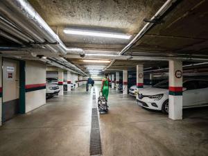 Un estacionamiento con autos y una persona caminando en él. en ibis Montargis, en Montargis
