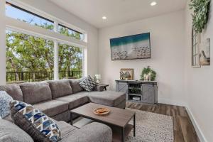 una sala de estar con un sofá y una mesa en Riverside Luxury A/B, Sleeps 12!, en Gruene