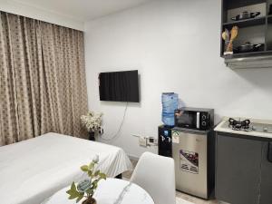 a room with a bed and a table and a tv at Mathel Studio Home in Marimbeti