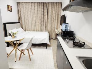 a room with a bed and a table and a kitchen at Mathel Studio Home in Marimbeti +2 photos
