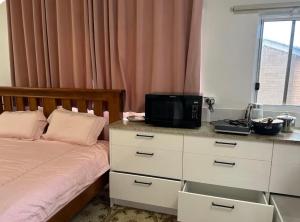 a bedroom with a bed and a desk with a television at Mains Rd 超大4人带厨房卫浴办公 M1 in Brisbane