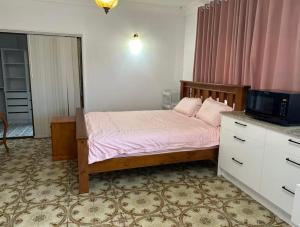 a bedroom with a bed with pink sheets and a tv at Mains Rd 超大4人带厨房卫浴办公 M1 in Brisbane +34 photos