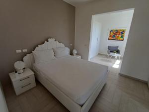 a bedroom with a large white bed and a chair at TRACADERO Beach Club & Holidays Rentals in Bayahibe