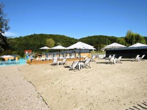 een groep stoelen en parasols op een strand bij Holiday homes with swimming pool, close to the sea in Wapnica