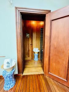 un couloir avec une salle de bains équipée d'un lavabo et d'une porte dans l'établissement Vila dos Pinheiros, à Campos do Jordão