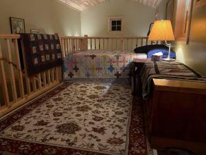 a bedroom with a bed and a table with a lamp at Rush River Cottage & Gardens in Ellsworth