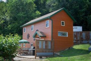 a large wooden house with a patio and a fence at Rush River Cottage & Gardens in Ellsworth