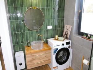 a bathroom with a washing machine and a mirror at Green Hill Domyslow, 6 persons in Domysłów