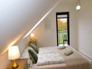 a bedroom with a bed and a staircase with a window at Green Hill Domyslow, 6 persons in Domysłów
