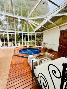 - une piscine dans une pièce dotée d'un plafond en verre dans l'établissement Vila dos Pinheiros, à Campos do Jordão