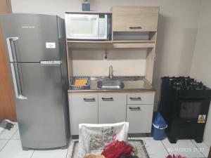 een kleine keuken met een koelkast en een magnetron bij Apartamento Ótima Localização Turismo Faculdade in Bento Gonçalves
