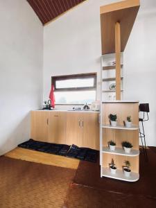 a room with a bed with potted plants in it at Lavenda homestay syari'ah in Dieng