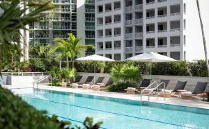 una piscina con tumbonas y sombrillas en Brickell 32th Floor AKA by Palermo Home Miami, en Miami