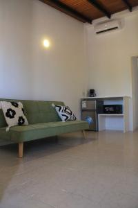 a living room with a green couch with pillows on it at Vida Playa El Agua in La Mira