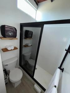 a bathroom with a toilet and a glass shower stall at Vida Playa El Agua in La Mira