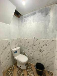 a bathroom with a toilet and a bucket in it at Lavenda homestay syari'ah in Dieng +6 photos