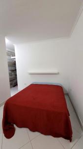 a white room with a red blanket on a bed at Casa Azul Jaraguá in São Sebastião