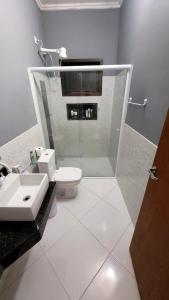 a bathroom with a shower and a toilet and a sink at Casa Azul Jaraguá in São Sebastião