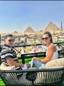 a man and a woman sitting at a table with food at Kayan Pyramids View in Cairo
