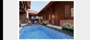 a person standing next to a house with a swimming pool at Ndalem Argupta in Kalibeber
