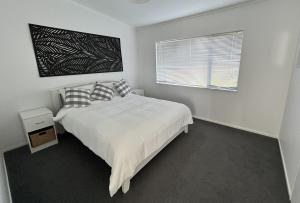 Giường trong phòng chung tại Kai Iwi Lakes - The Shores Lakefront Retreat