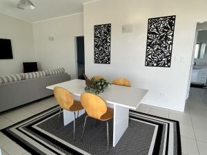 a dining room with a white table and chairs at The Shores Lakefront Retreat in Omamari