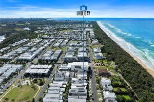 Nalu Beach House - Kingscliff Getaway by uHoliday في كينغسكليف: اطلالة جوية على شاطئ مع شقق سكنية