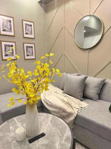 a living room with a vase with yellow flowers on a table at Ivory Residences in Davao City