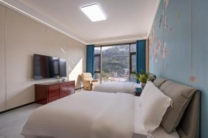 een slaapkamer met een bed, een bank en een tv bij 花筑庐江满山红遍民宿  +97 foto's