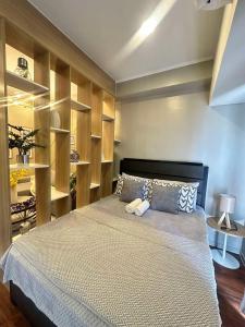 a bedroom with a large bed with wooden shelves at Ivory Residences in Davao City