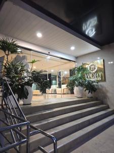 a lobby with stairs and potted plants in a store at Ivory Residences in Davao City +9 photos