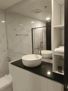 a white bathroom with a sink and a mirror at Ivory Residences in Davao City