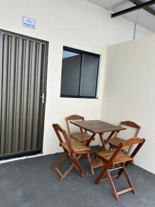 a wooden table and two chairs next to a window at Espaço completo com garagem, estrutura e móveis novos! in Rondonópolis