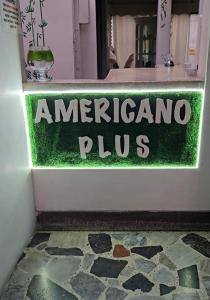 Un cartel que anuncia un americano plus en la puerta de una tienda. en Hotel Americano Plus, en Pereira