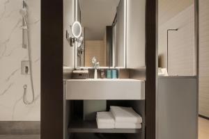 銀川市にあるNovotel Yinchuan Lanxiguの白い洗面台と鏡のあるバスルーム +24枚の写真