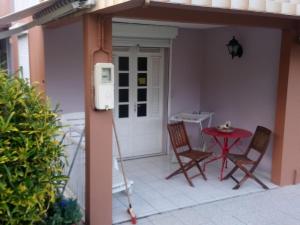 a patio with two chairs and a table on a porch at Philippe & Arlette SMITH in Sainte-Luce