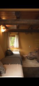 une chambre avec deux lits et une fenêtre dans l'établissement Cabañas Bendita Tierra- Crespin, à Los Molles