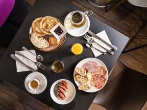 a table topped with plates of breakfast foods and drinks at Mercure Nancy Centre Place Stanislas in Nancy