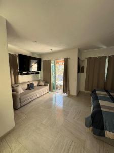 a large living room with a couch and a tv at Villa Yolanda in Acapulco +11 photos