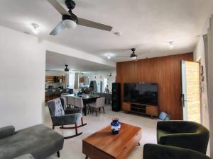 a living room with a couch and a tv and a table at Villa Yolanda in Acapulco