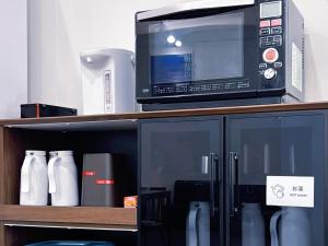 a microwave oven sitting on top of a shelf at Hotel Crane Tachibana in Miyazaki