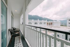 ein Balkon mit einem Stuhl und Blick auf ein Gebäude in der Unterkunft Marina Gallery Resort-KACHA-Kalim Bay by Sugar Marina Boutique Hotels in Patong Beach