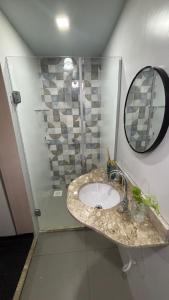 a bathroom with a sink and a shower with a mirror at Casa Janela Azul in Belém +7 photos