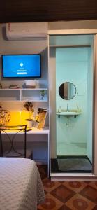 een kamer met een bureau met een televisie en een tafel met een bed bij Casa Janela Azul in Belém