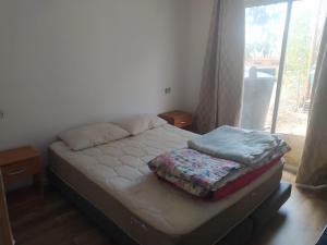 a small bed in a room with a window at Cabaña entre eucaliptos en Huaquén 3D 1B más patio in Guaquen